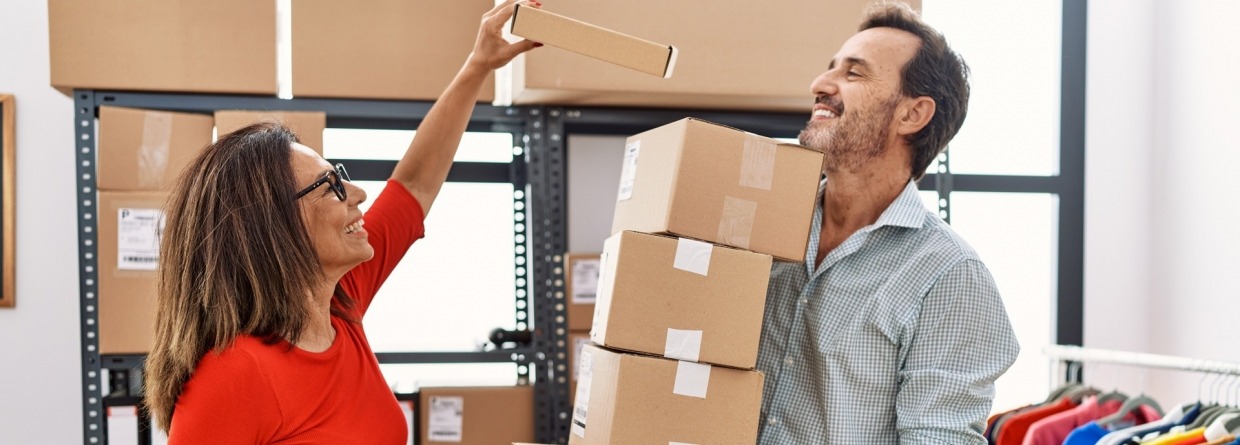 Een man en vrouw hard aan het werken om de pakketjes in te pakken om te verzenden