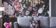 Fotobehang met bloemen achter grijze bank